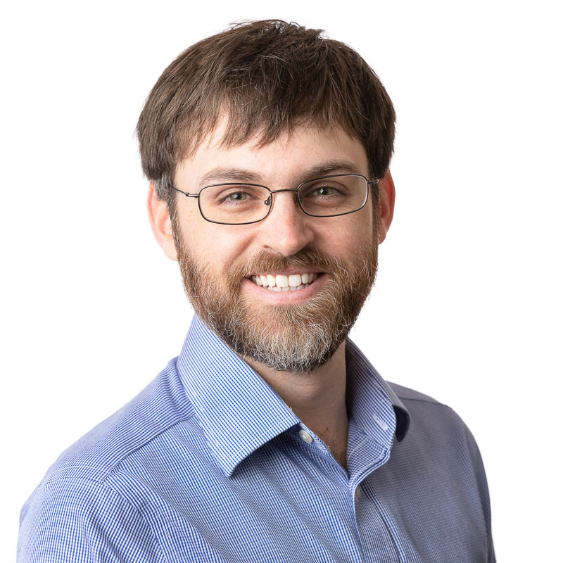 Professional business headshot demonstrating studio lighting and clean branding on a white background.